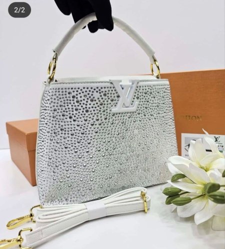 حقيبة نسائية فاخرة بتصميم لامع مرصّع يلفت الأنظار، من وحي Louis Vuitton. أنيقة وعملية، مع مقبض علوي وحزام كتف قابل للفصل، مثالية للمناسبات والسهرات لإطلالة راقية ومميزة.