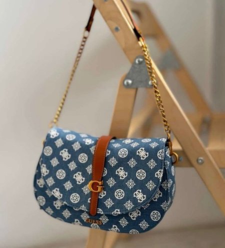 حقيبة نسائية أنيقة بتصميم عصري ونقشة جذابة من GUESS، مزودة بسلسلة كتف أنيقة ولمسة جلدية فاخرة. خفيفة وعملية، مثالية للمشاوير اليومية وتضيف لمسة أناقة عصرية لإطلالتك.