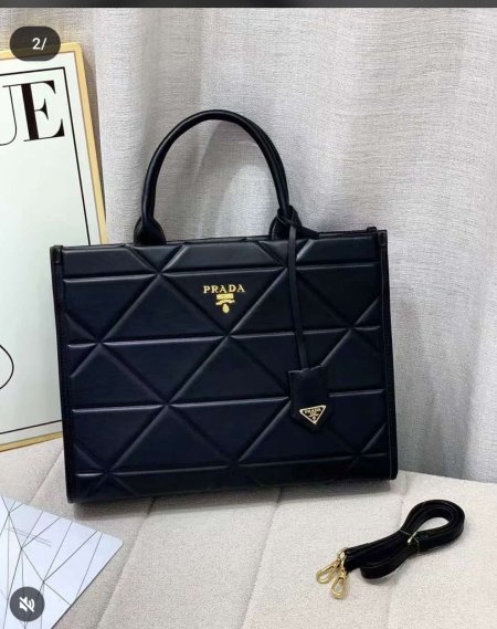 حقيبة نسائية فاخرة بتصميم مبطّن أنيق من Prada، بلون أسود كلاسيكي مع تفاصيل ذهبية راقية. عملية وواسعة مع مقبض علوي وحزام كتف، مثالية للاستخدام اليومي والمناسبات بإطلالة أنثوية راقية.