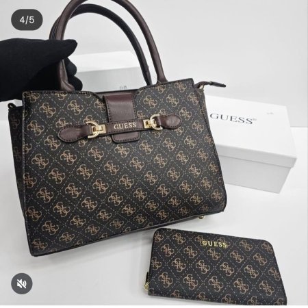 حقيبة نسائية أنيقة وعملية بتصميم كلاسيكي فاخر من GUESS، بنقشة مميزة وتفاصيل جلدية مع إغلاق أنيق ولمسات ذهبية راقية. مرفقة بمحفظة متناسقة، مثالية للاستخدام اليومي والعمل بإطلالة أنثوية أنيقة