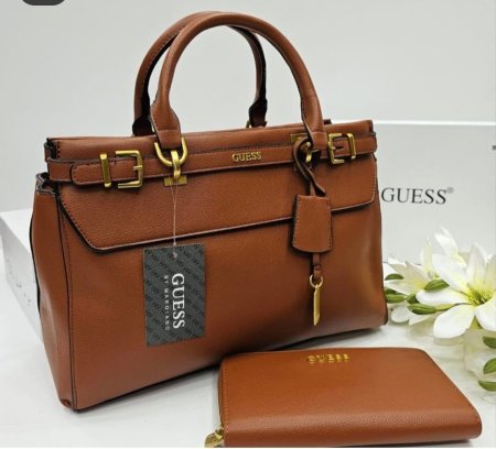 حقيبة نسائية راقية بتصميم كلاسيكي فاخر من GUESS، بلون بني أنيق مع تفاصيل ذهبية تضيف لمسة فخامة. واسعة وعملية مع محفظة متناسقة، مثالية للعمل والمشاوير اليومية بإطلالة أنثوية أنيقة
