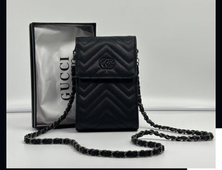 حقيبة كروس صغيرة أنيقة بتصميم مبطّن فاخر من Gucci، بلون أسود كلاسيكي مع شعار GG وسلسلة معدنية أنيقة. خفيفة وعملية، مثالية لحمل الهاتف والأساسيات بإطلالة راقية وعصرية