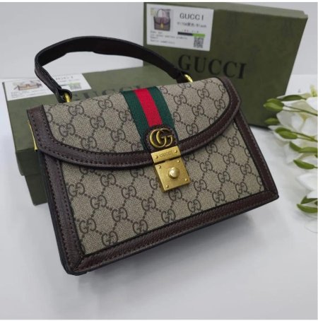 حقيبة نسائية فاخرة من Gucci بتصميم كلاسيكي أنيق، مزينة بنقشة GG الشهيرة وشريط الألوان المميز مع قفل ذهبي راقٍ. مثالية لإطلالة فخمة تجمع بين الأناقة والعملية في كل مناسبة.