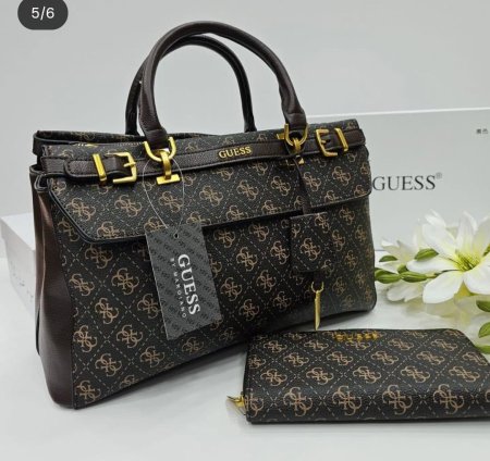 طقم حقيبة نسائية أنيق من GUESS بنقشة مميزة ولمسات ذهبية فاخرة، يضم حقيبة يد عملية مع محفظة متناسقة. اختيار مثالي لإطلالة راقية تجمع بين الفخامة والتنظيم في الاستخدام اليومي.