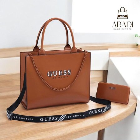 حقيبة أنيقة من GUESS بلون بني دافئ ولمسة سلسلة عصرية، مع حزام كتف عملي ومحفظة متناسقة. تصميم يجمع بين الفخامة والبساطة، مثالي لإطلالة يومية راقية ولمناسباتك بكل أناقة.
