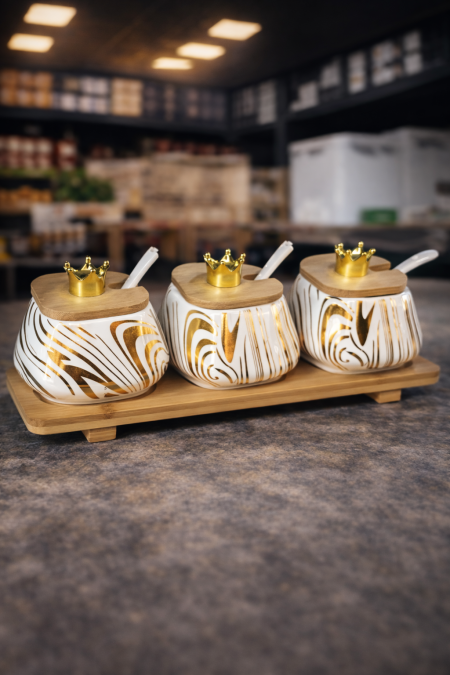 طقم علب تقديم فاخر 3 قطع 👑✨ تصميم أنيق بنقشة بيضاء وذهبية مع أغطية خشب وتاج ذهبي، قاعدة خشبية وملعقة لكل علبة… لمسة فخامة راقية للمطبخ والسفرة 🍯🌿