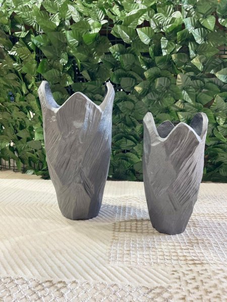 فازتان ديكور بتصميم عصري مستوحى من الشكل الطبيعي، بلون رمادي هادئ ولمسة مطفية أنيقة. تضيفان إحساساً بالبساطة والرقي لأي مساحة، مثالية للديكور المودرن وتناسب طاولات الصالون والزوايا الهادئة، سواء مع الورد الجاف أو للعرض كقطعة فنية مستقلة.