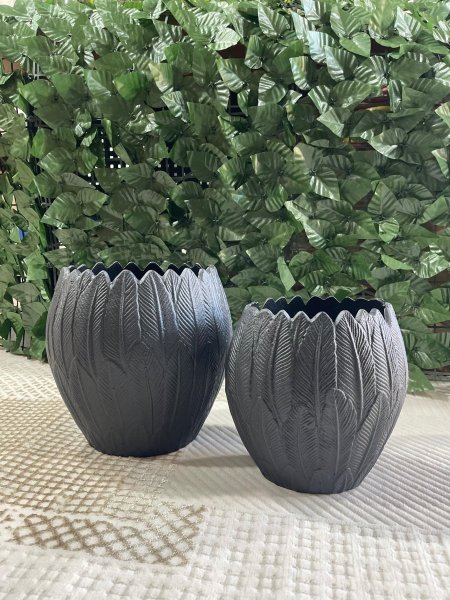 فازتان ديكور بتصميم أوراق أنيق وملمس بارز، بلون رمادي داكن مطفي يضفي فخامة وهدوء على المكان. مثاليتان لتزيين الطاولات والرفوف، وتناسبان الديكور العصري وتبدوان جميلتين مع الورد الجاف أو كقطعة ديكور مستقلة.