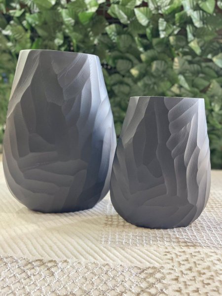 فازتان ديكور بتصميم عصري بسيط وملمس هندسي ناعم، بلون رمادي هادئ أنيق. تناسب الديكور المودرن والمينيمال، وتضيف لمسة راقية للطاولات والرفوف، وتبدوان جميلتين مع الورد الجاف أو كقطعة ديكور مستقلة.